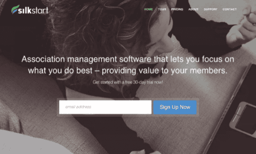 SilkStart homepage, with an email free trial signup and informative blurb against a background of a person using Silkstart on their laptop.