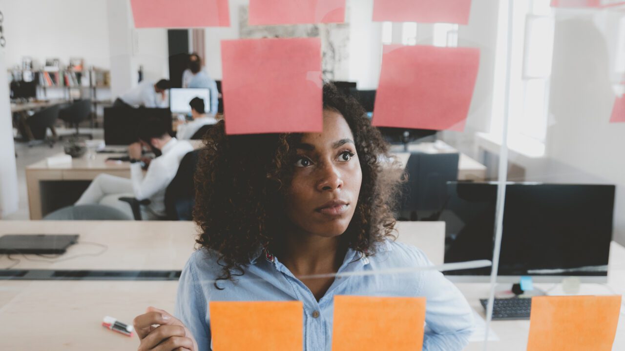 woman looking at sticky notes that would be replaced by membership software