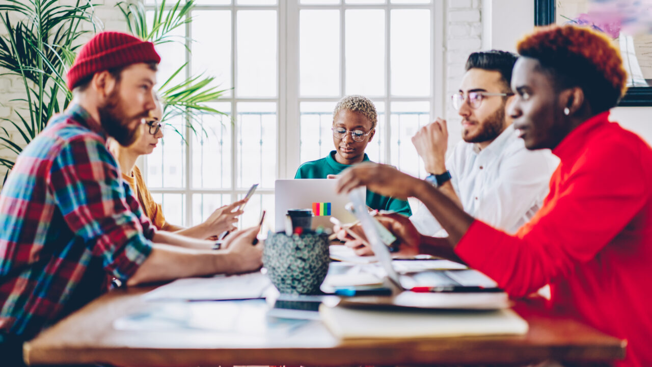 group of small staff sitting at a table discussing software options