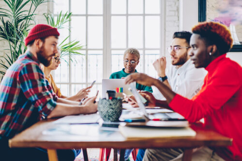 group of small staff sitting at a table discussing software options